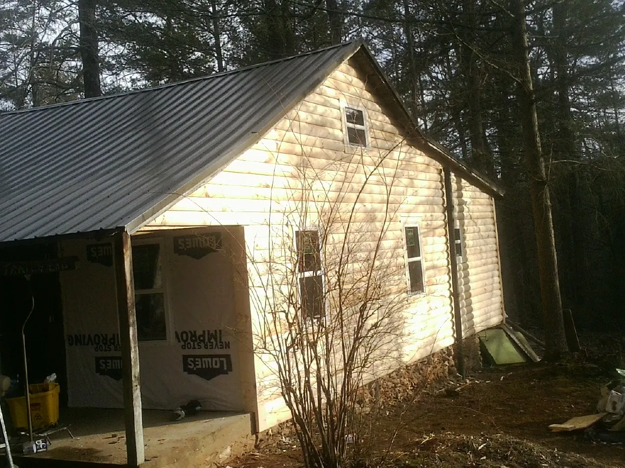 Log siding gable end under a dark metal roof edge in Ben Lomond