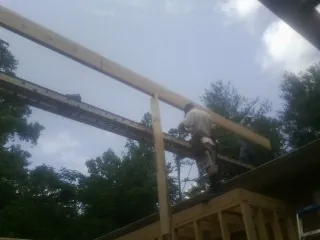 Carpenter setting a ridge beam over a new addition frame — Ice Dam Removal by Roofing Brothers in Ben Lomond